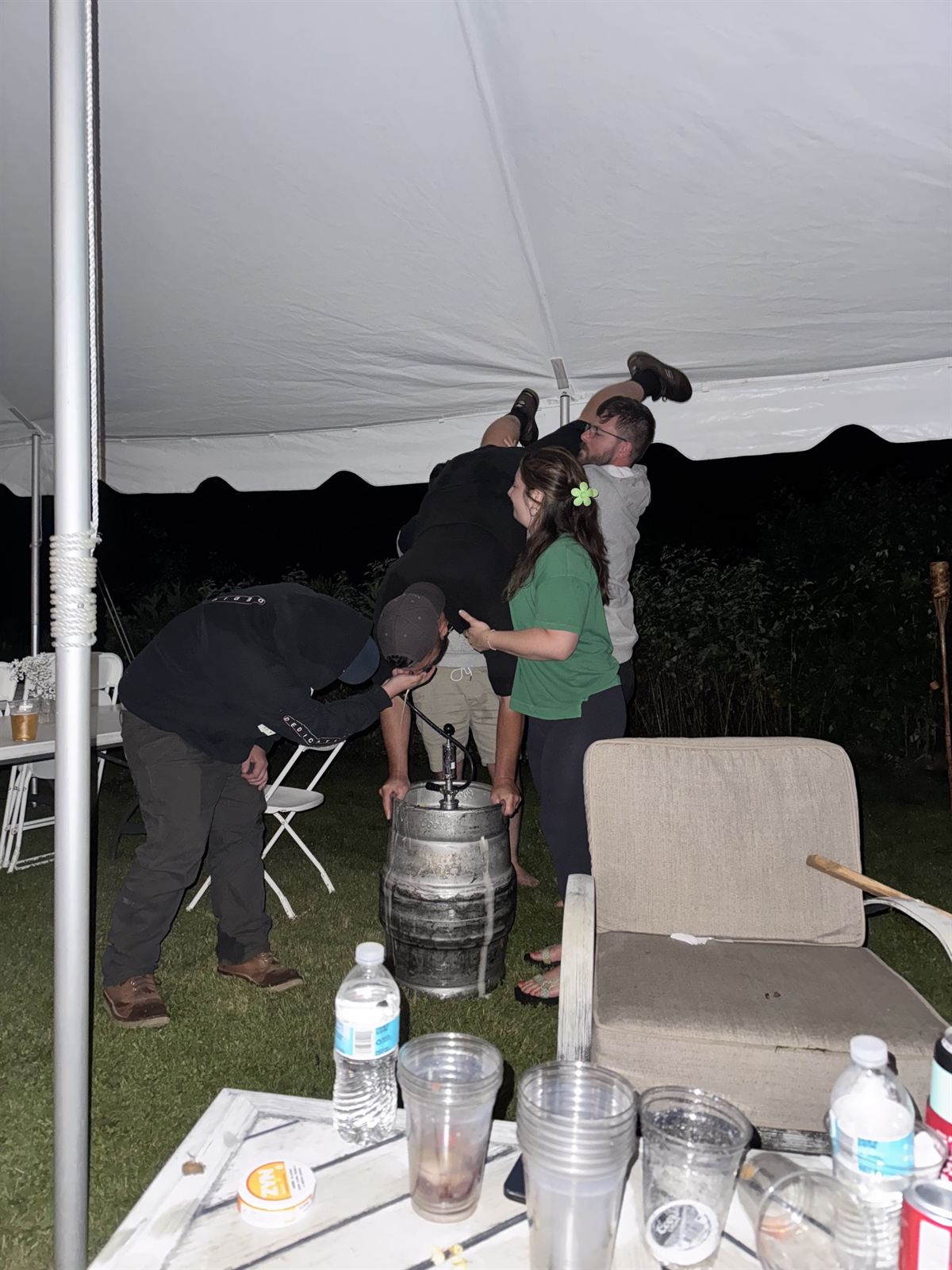 Around the keg under the tent at night