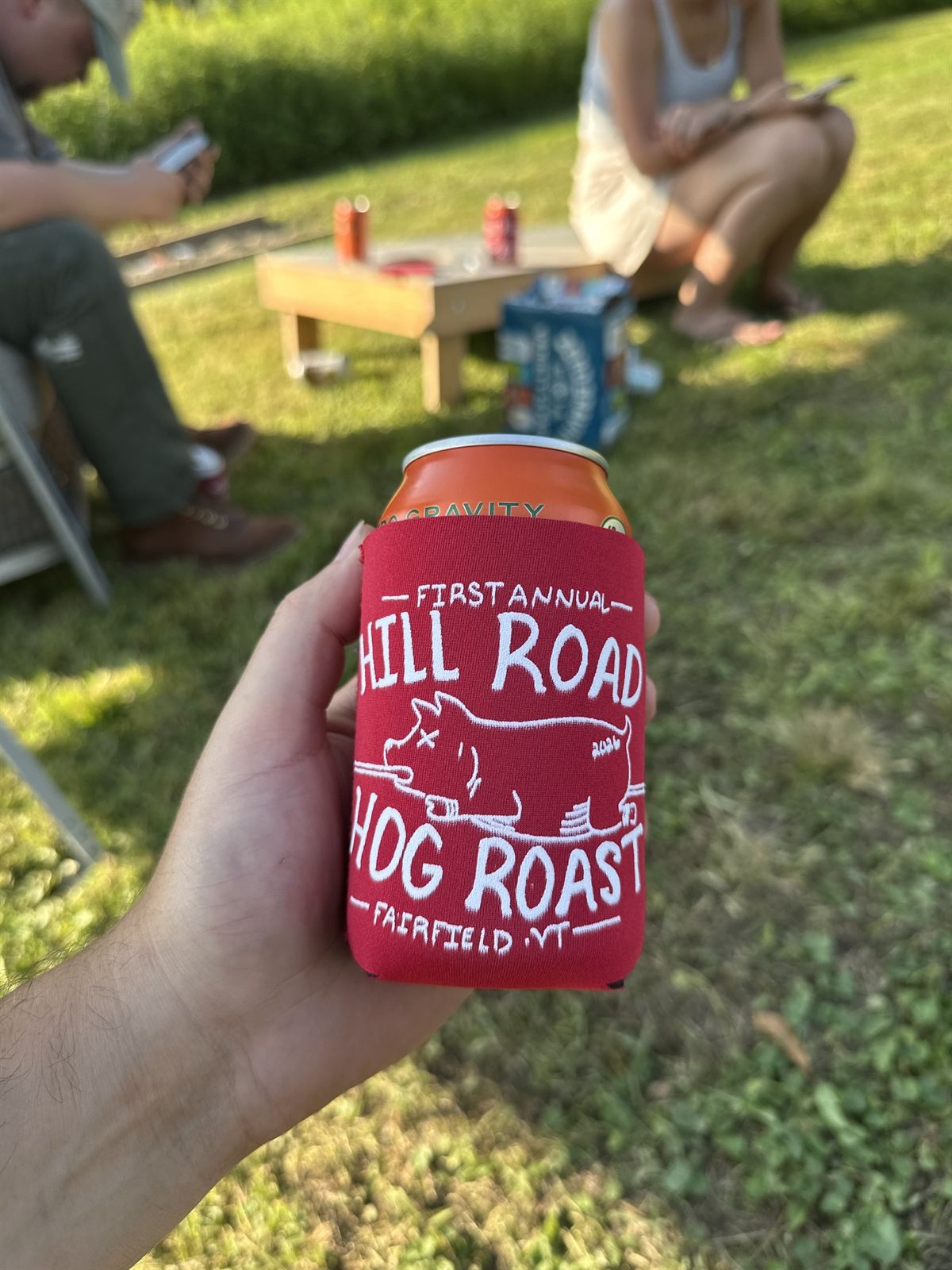 A Hill Road Hog Roast koozie in the sun