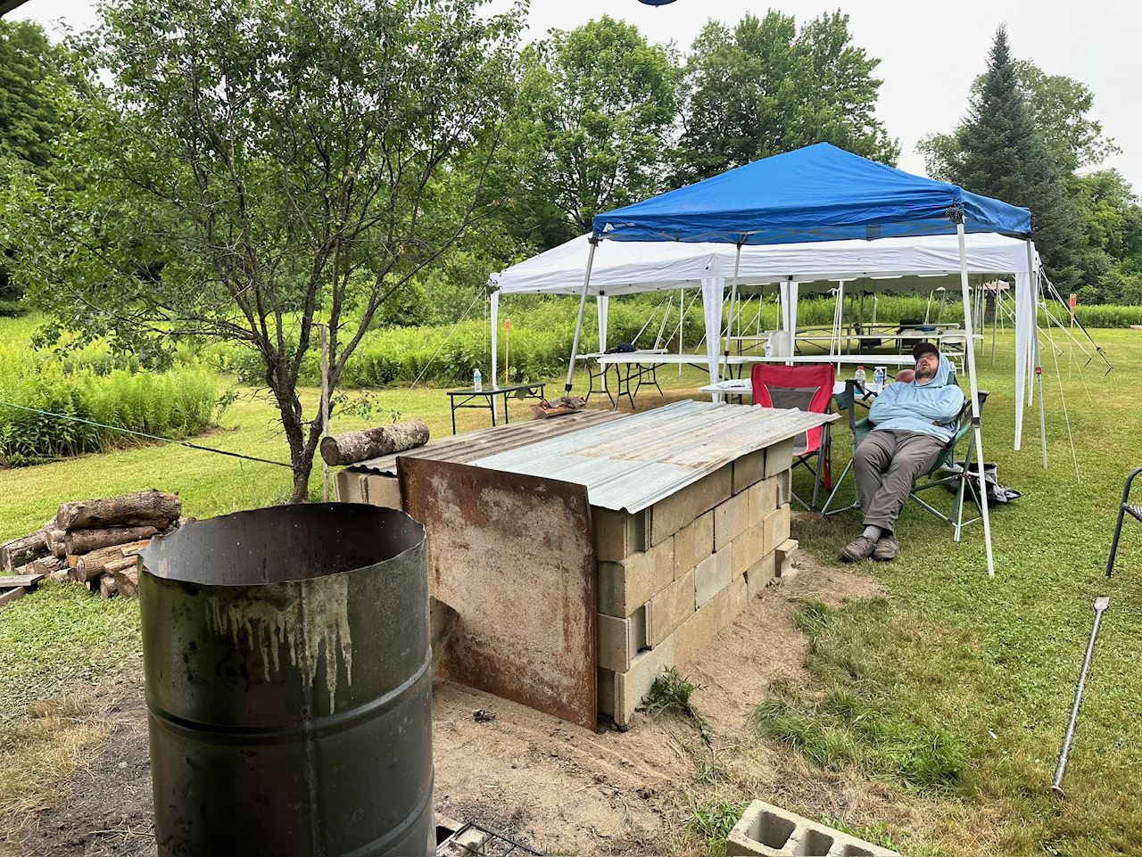The covered pit with tents behind it