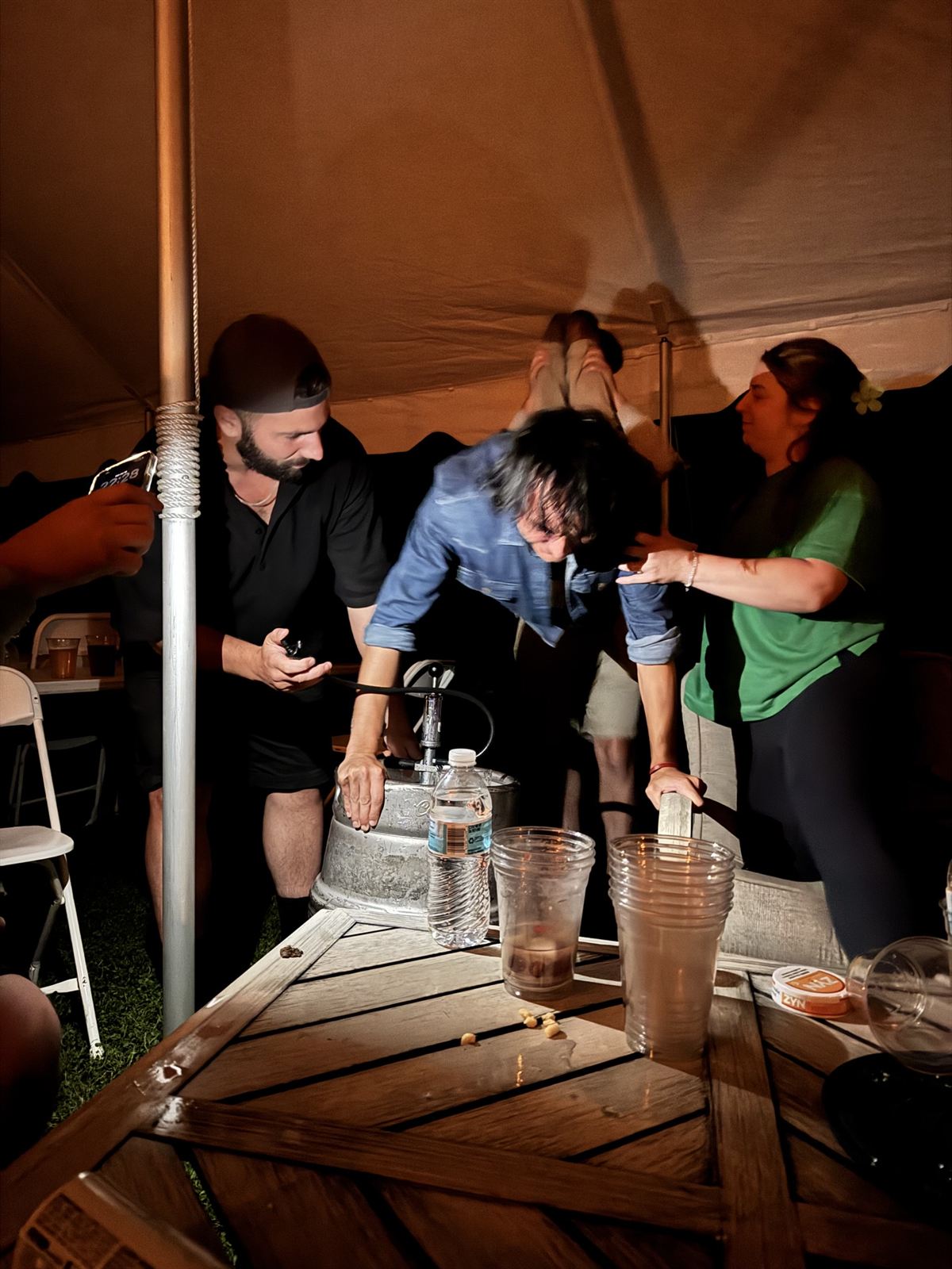 Tapping the keg under the tent
